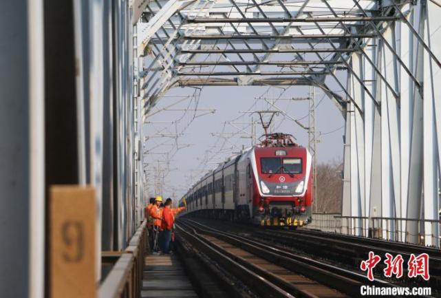 图为两名作业人员正在相互配合更换护木钩螺栓. 梁希 摄