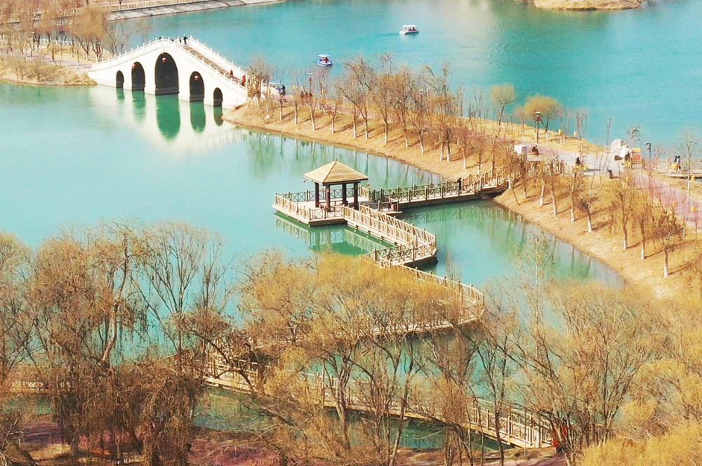 在新疆和田地区和田市昆仑公园,市民三五相聚,或闲逛游览,或划船嫦贩