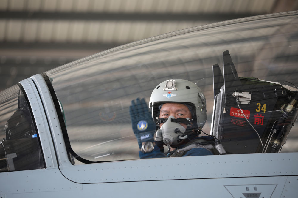 2月23日,复飞重返战位的一等功空军飞行员王建东手势示意机组,准备滑
