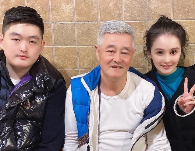 牛牛与小品演员张小飞拍摄了一张宣传照,图中他穿着深蓝色的中山装,手
