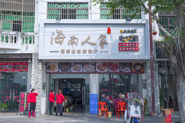 洁白的门头,暖棕色的招牌,"海南人家"四字娓娓道来,一侧的slogan让人