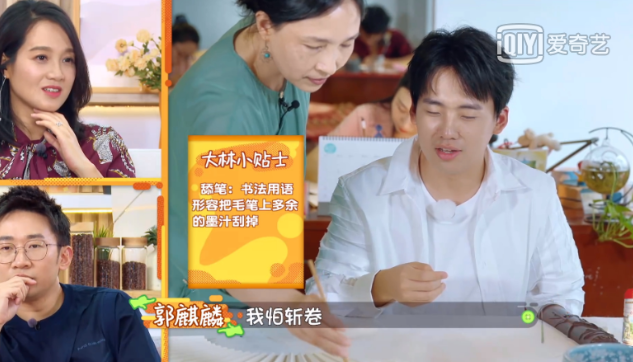 和其他嘉宾一起学写毛笔字,一拿起很顺手的就向老师请教:"这怎么舔笔?