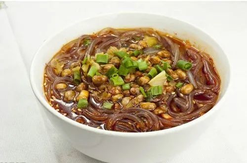 5,将煮好的粉丝捞出置于碗中,将酸豆角,花生米,香菜叶撒在表面,最后浇