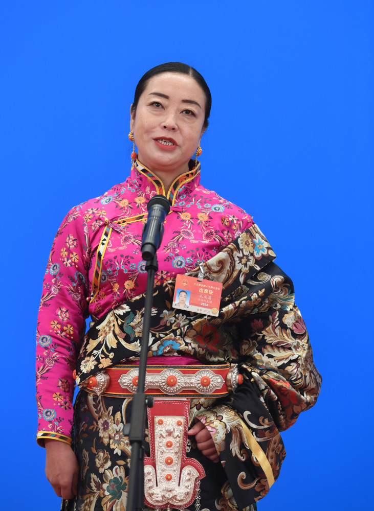 这是全国人大代表孔庆菊(左),木沙江·努尔墩通过网络视频方式接受