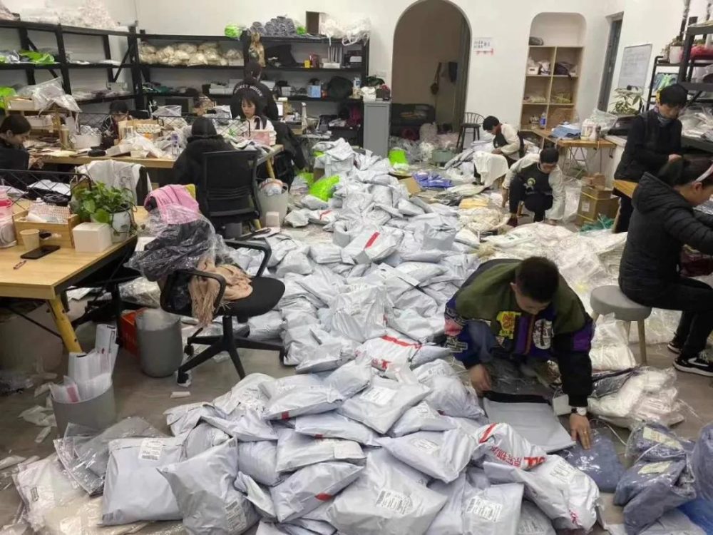服装门店刚刚开张,待发的快递堆积如山,20多位工作人员正在忙碌地打包