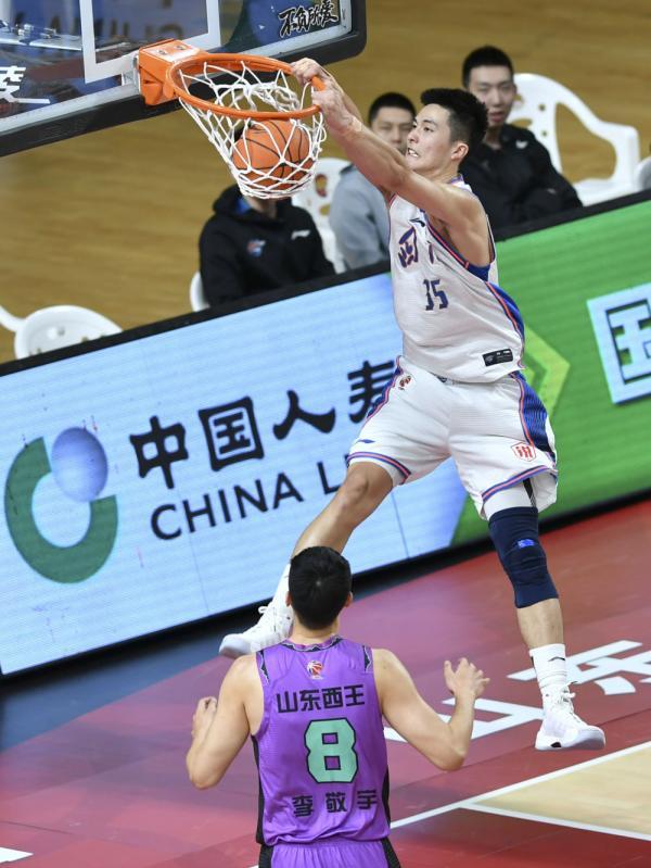 四川五粮金樽队球员朱松玮(上)在比赛中扣篮.