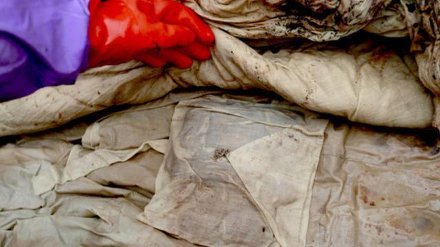 专家发现棺外的第一层保存完好,尸体被布和棉被衣服过得严严实实,虽然