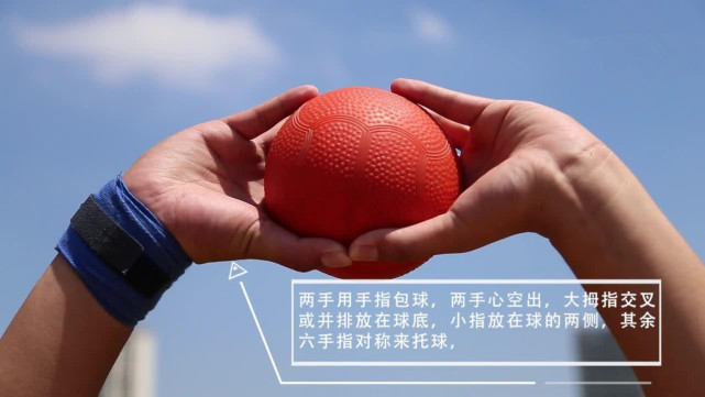 两只手的大拇指相对,其余四个手掌张开呈三角形,握球时手应该托住实心
