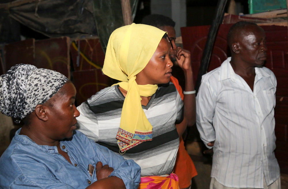 3月18日,人们在坦桑尼亚达累斯萨拉姆观看副总统哈桑发表讲话的电视