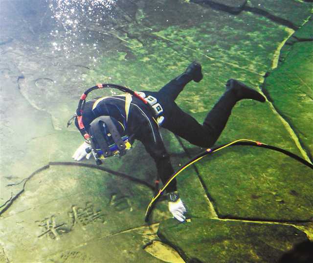 3月15日,在长江水下40多米的白鹤梁题刻无压容器罩内,潜水员在进行