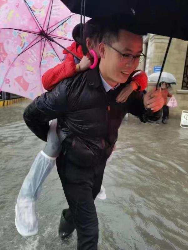 暴雨里温暖一幕小学校长背着孩子蹚水进校他能叫出校内近千位孩子的