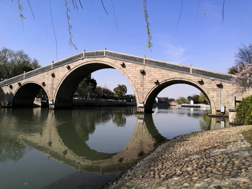 绿树红花,相映成趣,水多,桥多,有水就灵动,很容易见到古老的石拱桥