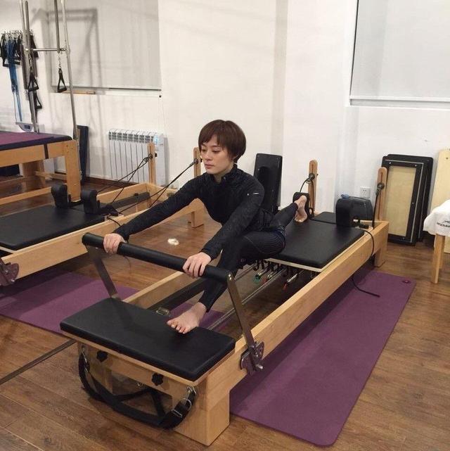 动作一:仰卧运动使身体平躺在瑜伽垫上,然后双脚踩住拉力器的脚踏部位