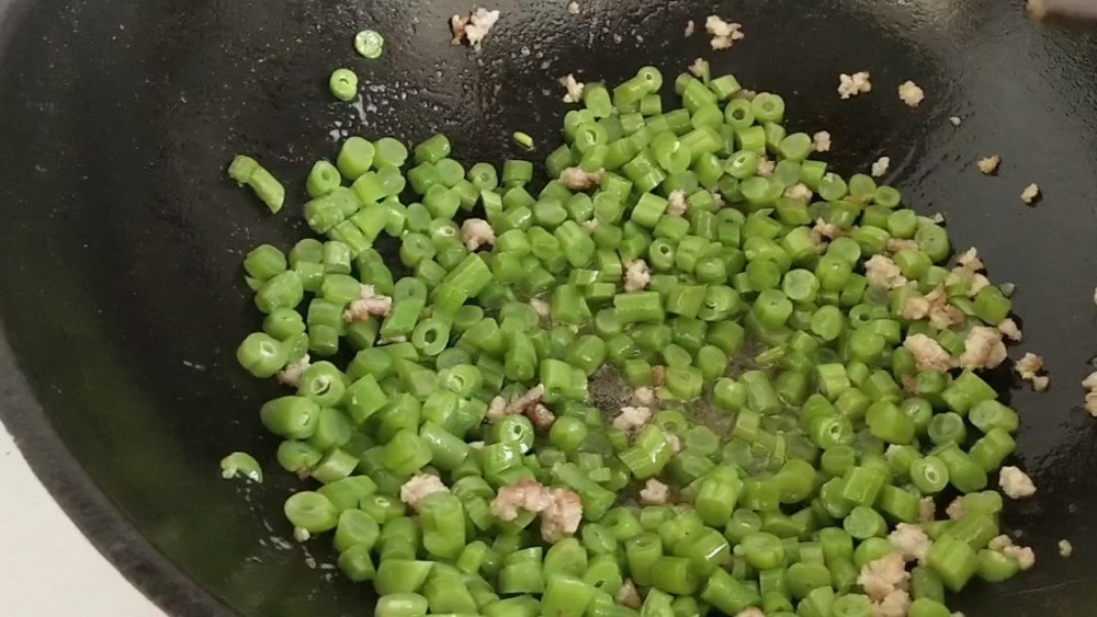 下入豆角粒翻炒,利用锅内的水和油煎炸一下一下豆角.口感会更好!