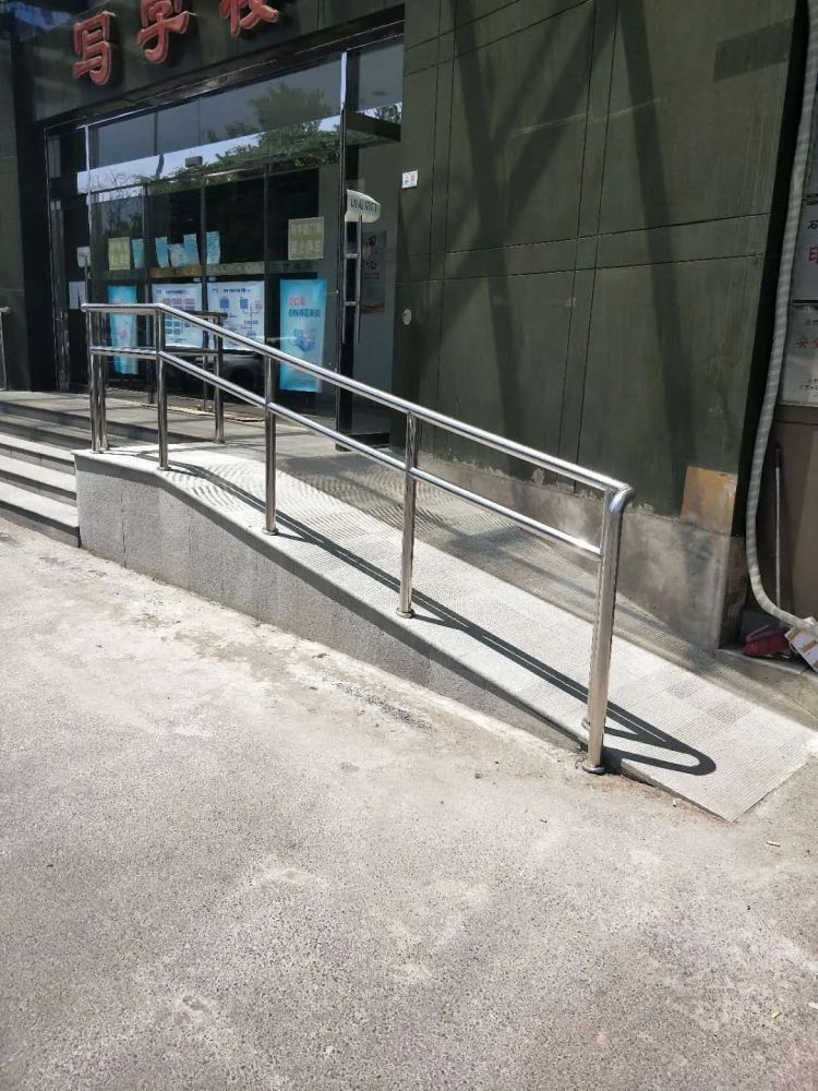 无障碍设施改造原来楼前的台阶已经变为平整的坡道并且加装了扶手一些