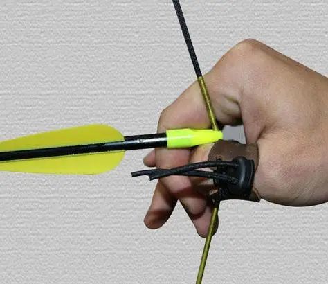 图:蒙古式射箭法是拉弓弦的手用大拇指扣弦,其他手指压在大拇指上,箭