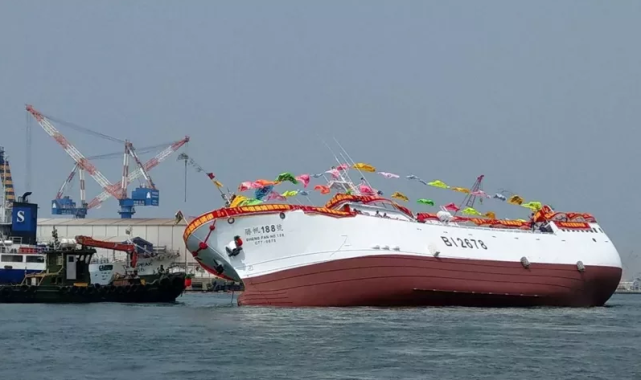 图片:浑身还插着彩旗的"胜帆188"号远洋渔船出现了严重侧倾.