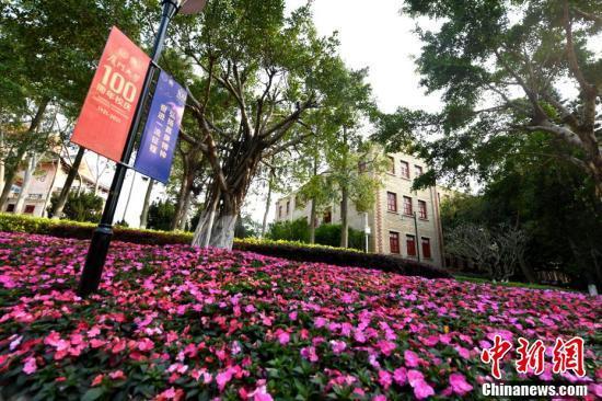 王东明 摄学生志愿者展示校庆吉祥物:"小百"与"小厦",寓意百年厦大.