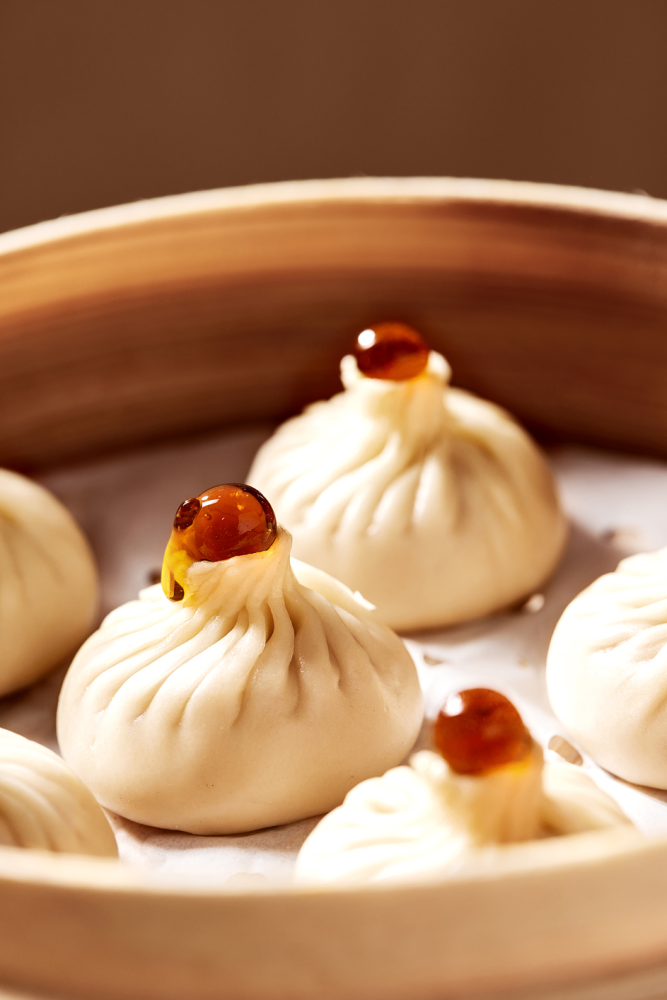 创意」,把杭州龙井和镇江香醋两种风味料汁做成爆珠放在小笼包的尖尖