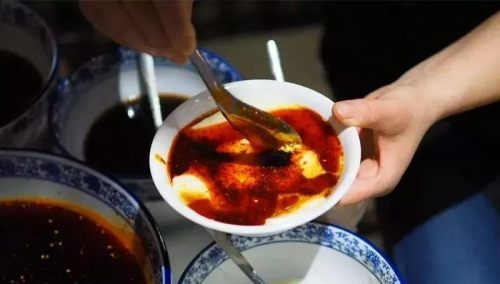 红艳艳的一碗,嫩嫩的豆腐冒出个尖儿,犹如火山积