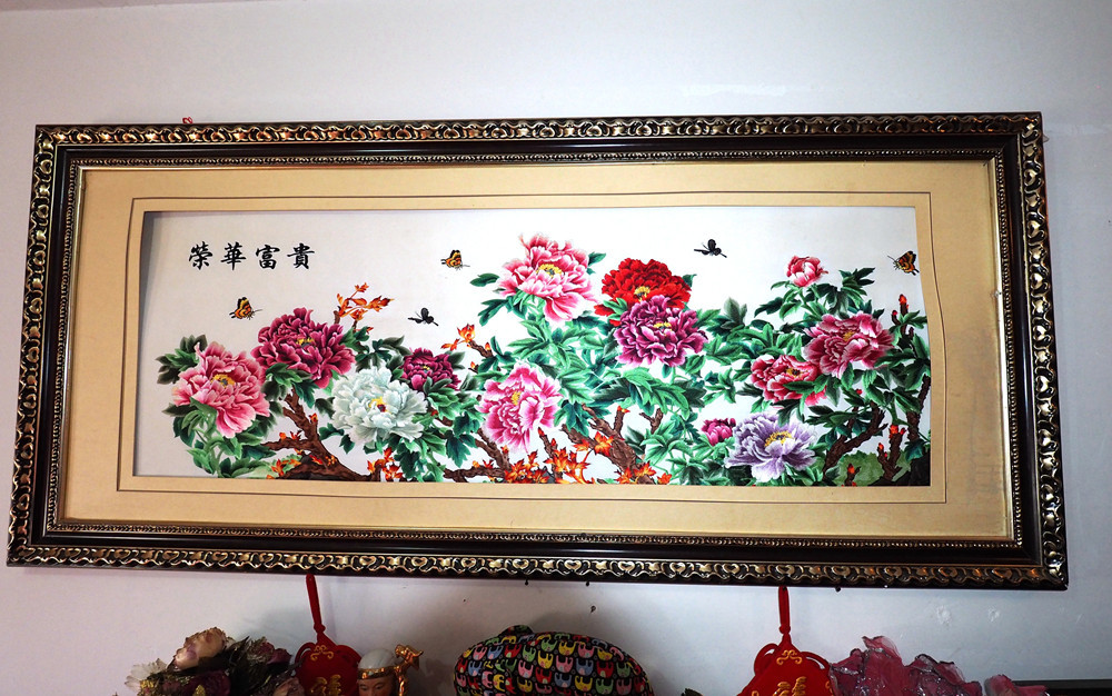 在刘联琴住的廉租房里,挂满了她做的十字绣.