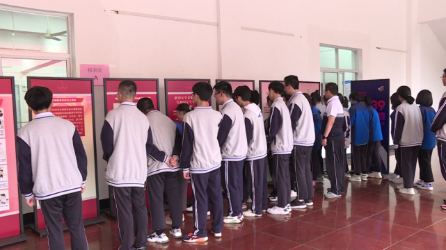 在青田中学体育馆内,学生们正在认真地通过展板了解国家安全知识.