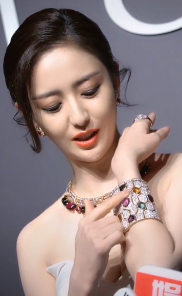 富婆佟丽娅高调出席活动穿v领裙秀出傲人上围一身行头上百万