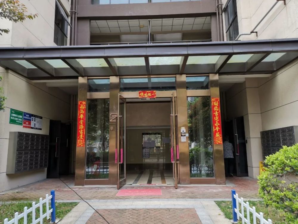 小区里,草皮大片大片枯死景观河水浑浊不堪单元门口,快递车辆以及非