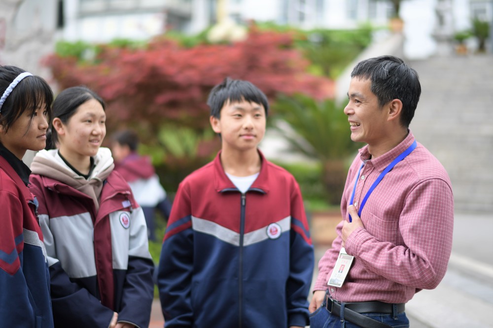 4月15日,楊明(右一)在貴州省畢節市黔西縣一中走訪曾經幫扶過的學生.