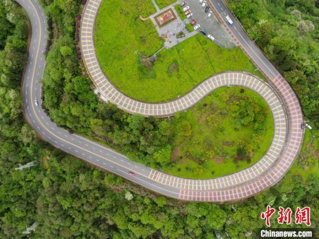 航拍江西井冈山生态盘山公路如长龙在绿色山间起舞