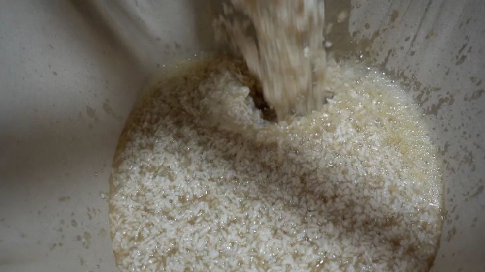 贺正梅边制作麦芽糖边介绍:这是麦芽面,熬糖时必须把麦芽面加进去,它