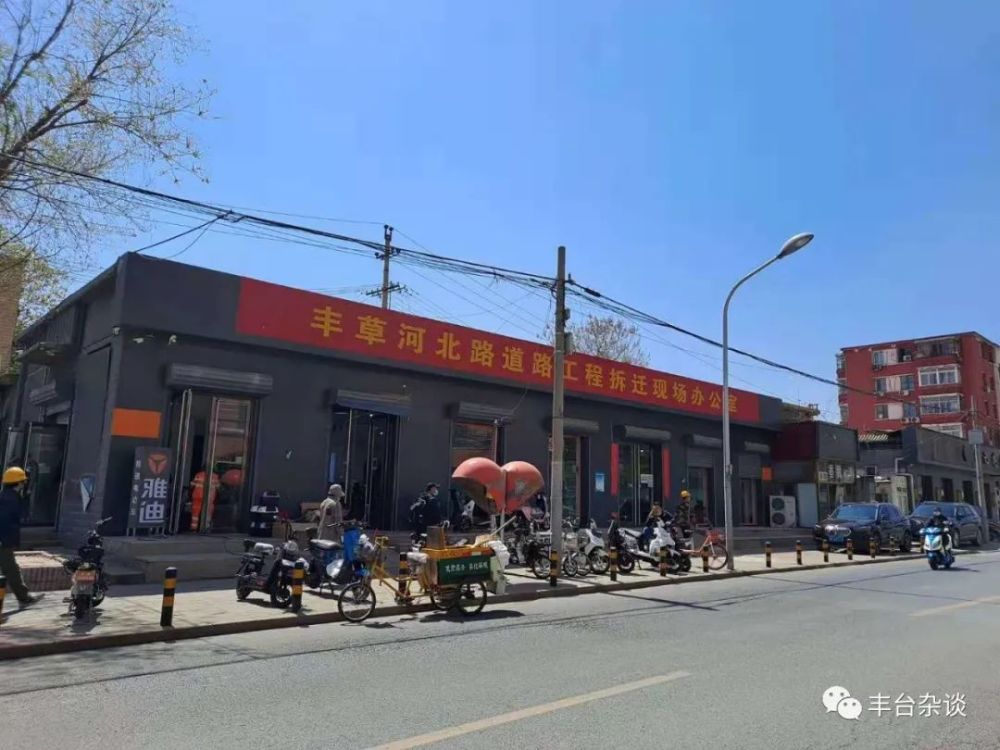 的长条幅丰草河北路道路工程拆迁现场办公室张贴了位于正阳大街某电动