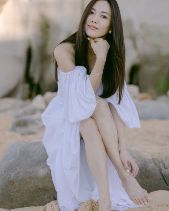 郭妃丽现身海边,她赤着脚坐在石头上或站在沙滩上凹造型,范儿十足,不