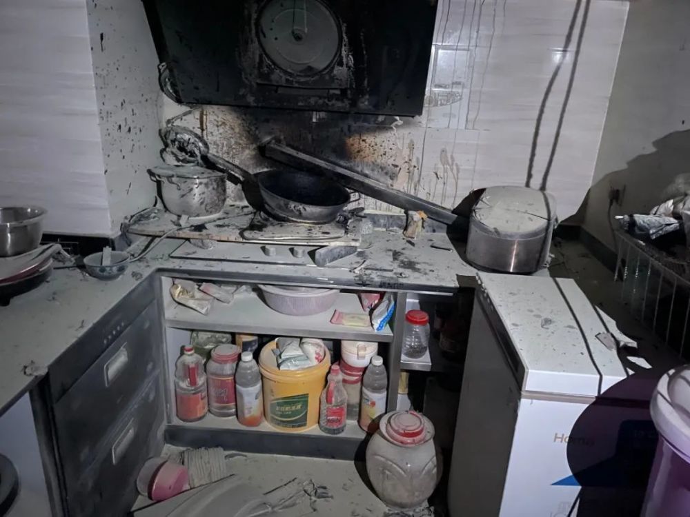 抽油烟机已经被烧成废铁 厨房的吊顶也已经脱落 客厅也被浓烟熏黑 经