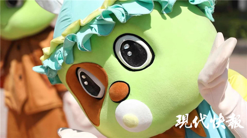 3月正是春游季,中午12点半,嬉戏谷的淘宝大街上,"囧囧狗"正在和游客摆