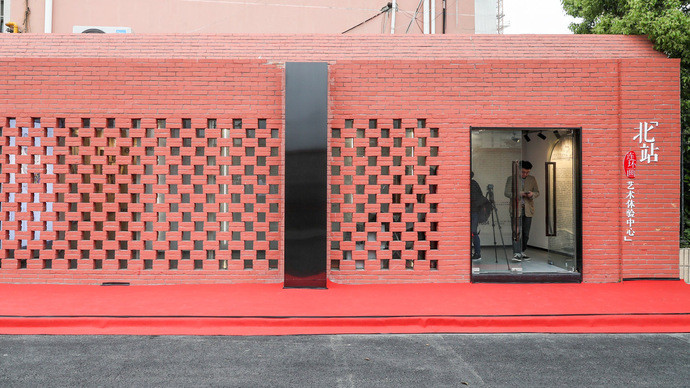 镂空的红砖墙,透出屋内的灯光,玻璃门旁的白字显示——"北站连环画