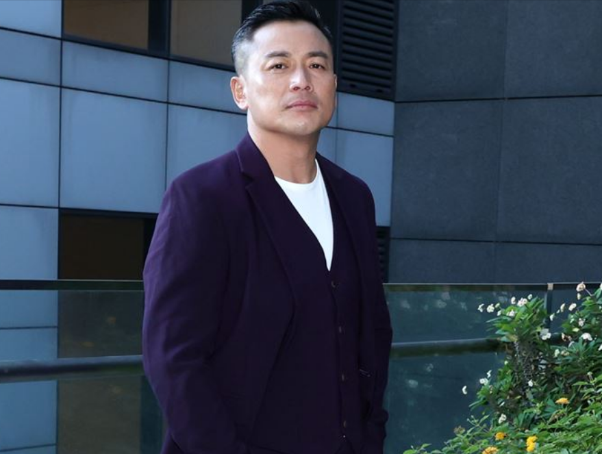 近照中,江宏恩穿着一身剪裁得体的深紫色西装出镜,搭配擦得锃亮亮皮鞋