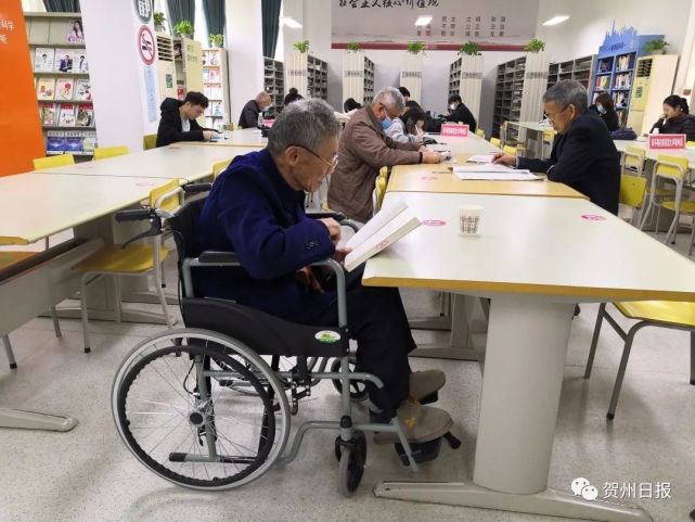 90歲高齡賀州一老人坐著輪椅來圖書館看書