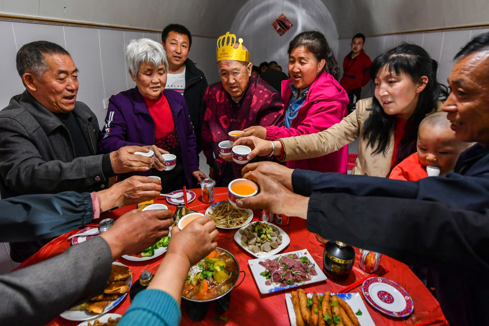 胡在忠(中)在寿宴上与家人们碰杯(4月24日摄).