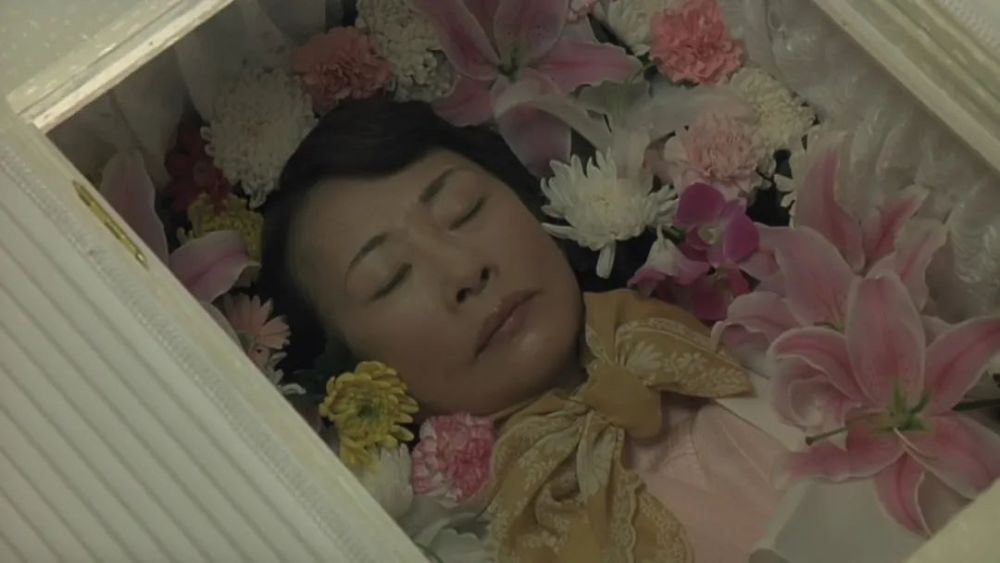 下有层层棉布垫着柔软舒适,再轻轻合上棺头用来瞻仰遗容的塑料板天窗