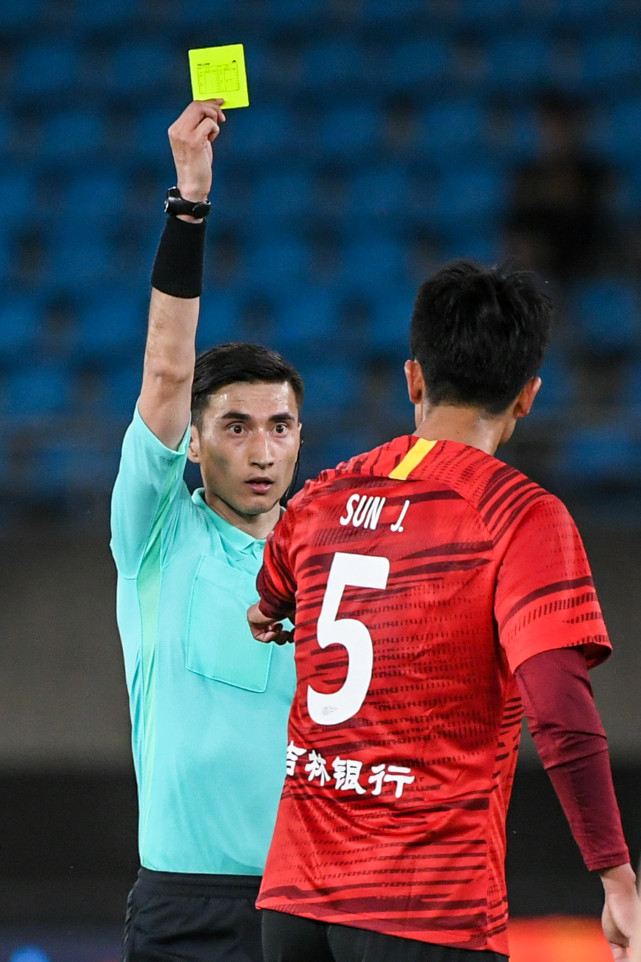 4月29日,主裁判麦麦提江·艾合麦提在比赛中向长春亚泰队球员孙捷(右)