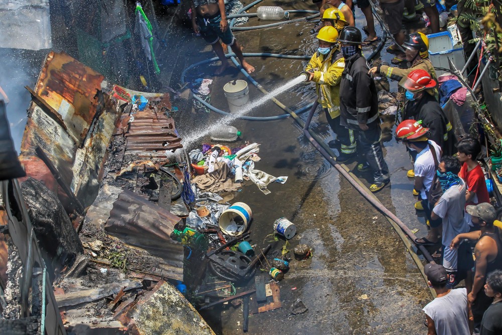 新华社发(乌马利摄)4月30日,消防员在菲律宾马尼拉一居民区灭火.