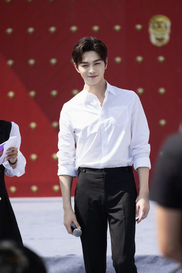 许凯穿白衬衫现身活动拥抱献花小女孩暖心十足