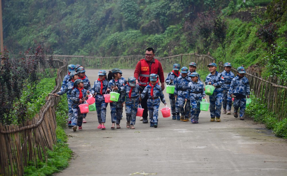 新华社记者 黄孝邦 摄在乌英苗寨,郑昌昊(左一)给学生卜秀文送台灯(1