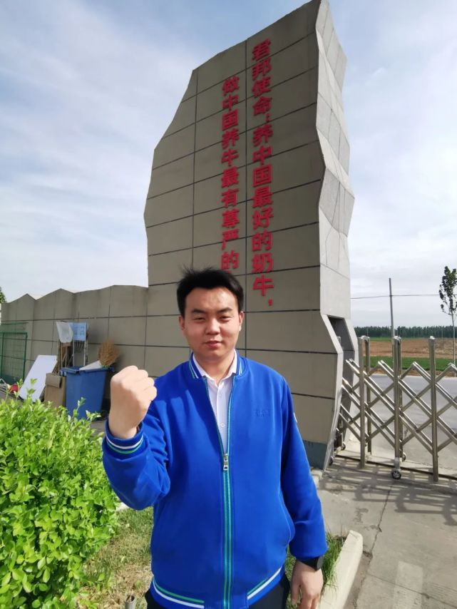 邓景润站在公司门口,为牧业大发展加油威县乐源君邦牧业大门口有一句