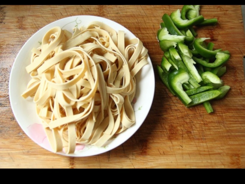 千张清洗干净,然后叠在一起,从上往下卷起,然后切粗丝.