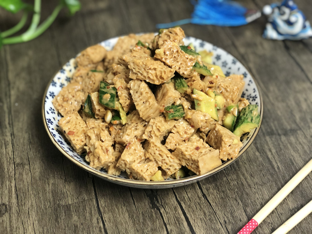 6,黄瓜拍成小段和面筋拌在一起,倒入麻酱汁,抓拌均匀就可以了.