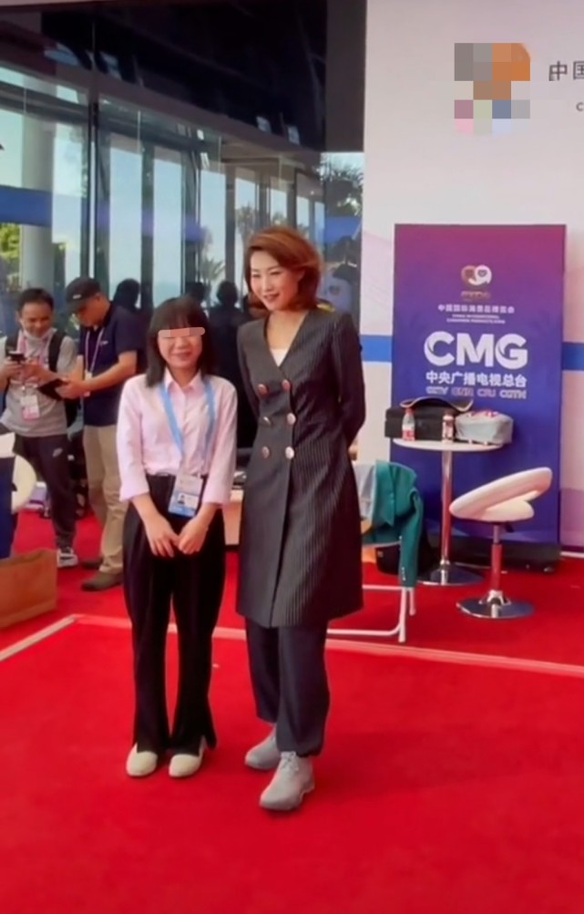 李梓萌与一位路人亲切合影,174cm的身高非常瞩目,1米2大长腿超级显眼.