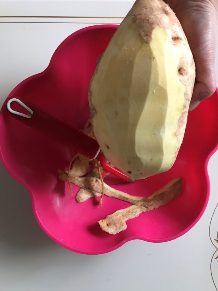 2,准备好的地瓜先洗干净,接着是用工具将地瓜皮去掉,这样去皮会更加