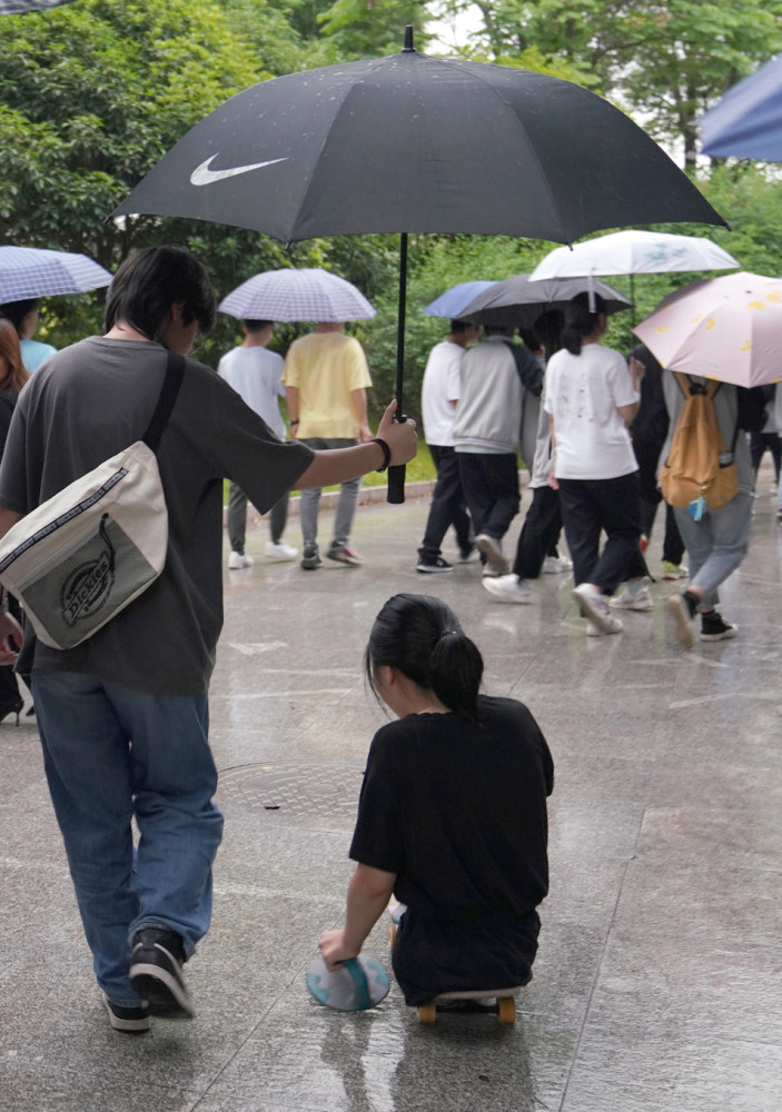 2021年5月10日,蒋张子怡在雨天行动不便,同学撑伞替她挡雨